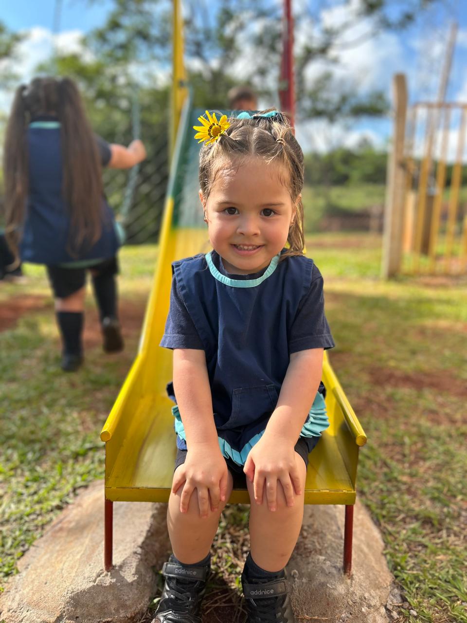 Niña jugando al aire libre en la escuela.